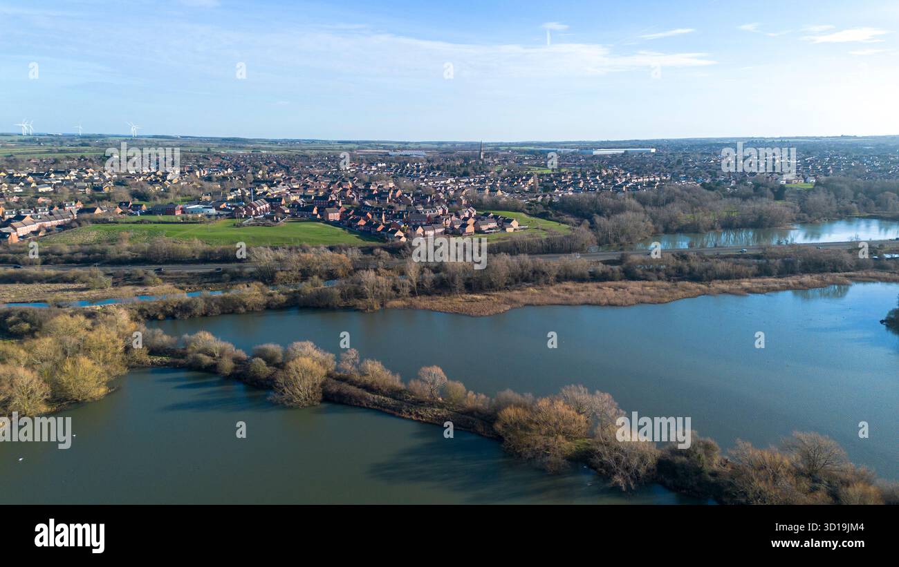 Blick aus der Vogelperspektive über das Naturschutzgebiet Irthlingborough Lakes and Meadows in den Nene Wetlands, Northamptonshire, mit der Stadt Irthingborough im Hintergrund. Stockfoto