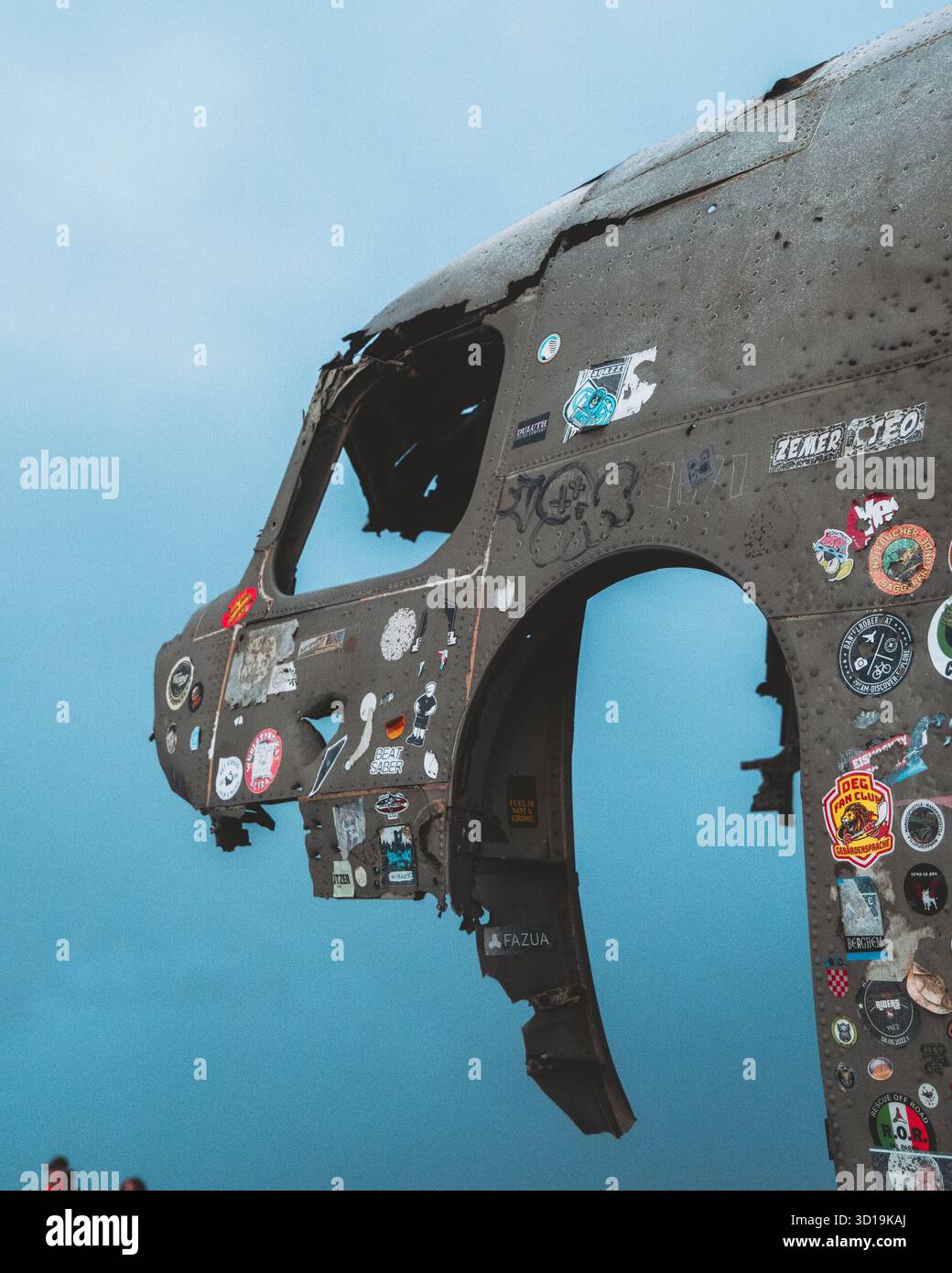 Blick auf den verwitterten Kadaver des verlassenen DC-3-Flugzeugs, verziert mit bunten Aufklebern am Himmel, ein eindringlicher Kontrast, Solheimasandur-Flugzeugwrack, Mýrdalshreppur, Island. Stockfoto