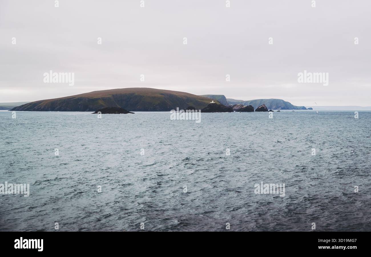 Blick auf die zerklüftete Insel unter bewölktem Himmel trifft auf das plätschernde Meer, eine ruhige aussicht auf die raue Schönheit der Natur, Shetland Islands, Schottland, Großbritannien. Stockfoto