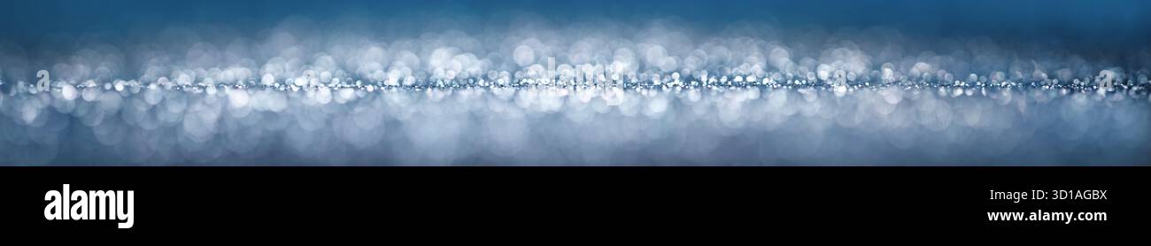 Blauer und silberner Glitzer verwischt als breiter Bannerhintergrund. Abstraktes Studio mit wunderschönen Fantasy-Bokeh-Kreisen. Stockfoto