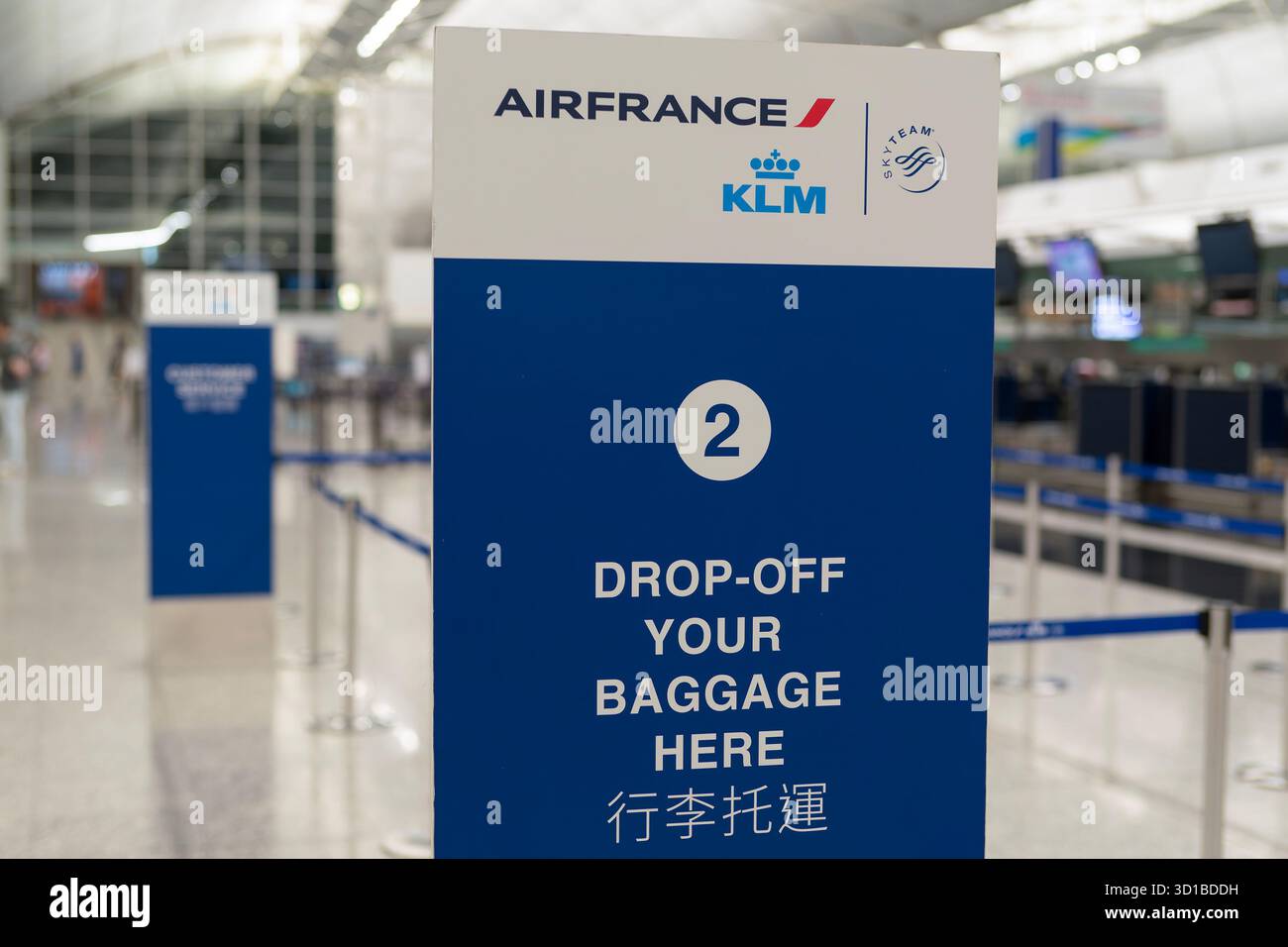Hongkong - 20. September 2025: Nahaufnahme eines vertikalen Check-in-Schilds für Air France KLM „Drop-Off Your Baggage here“ mit englischer und chinesischer Schrift Stockfoto