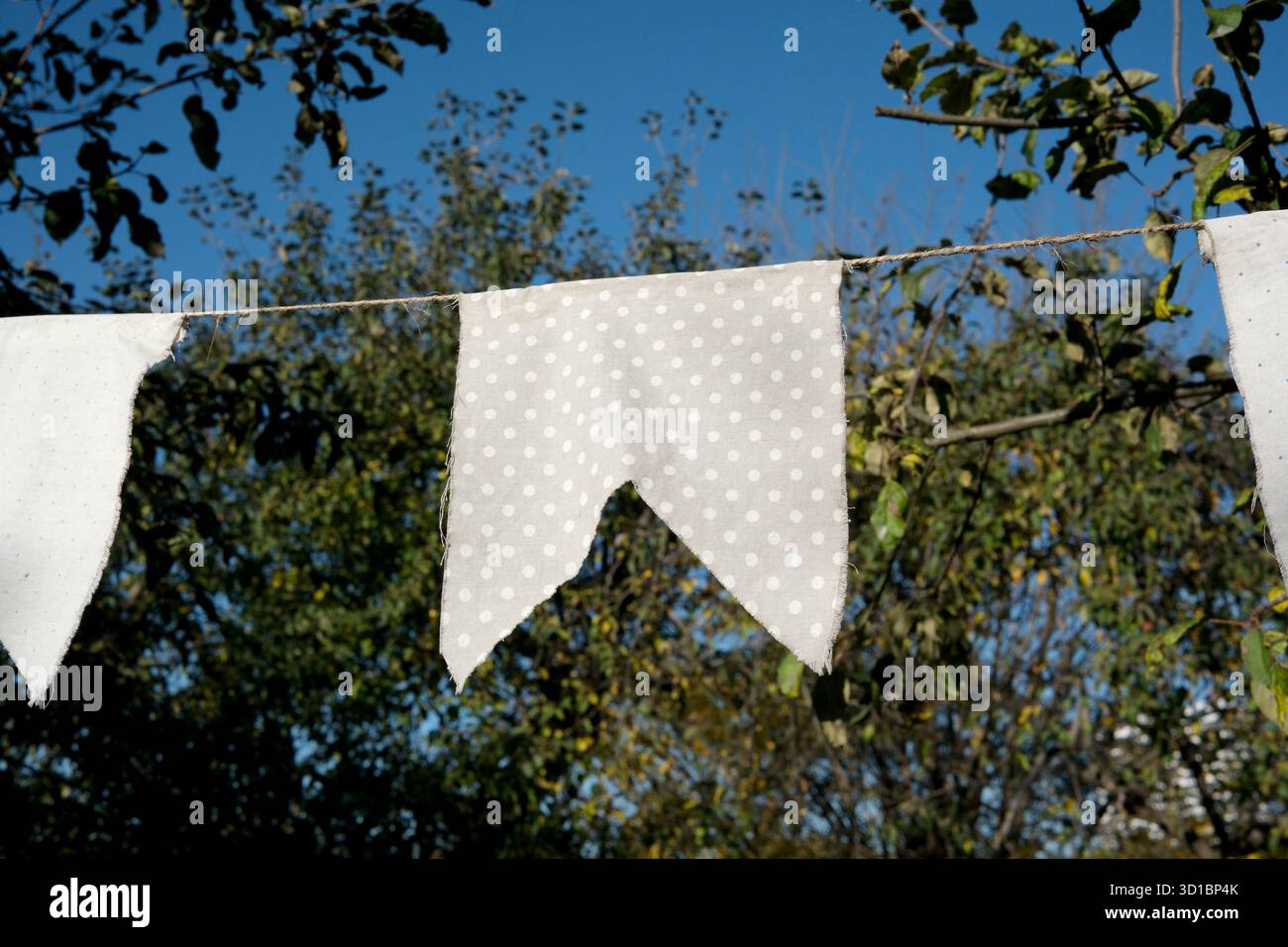 Feiern Sie die Natur in einem lebendigen Garten mit fröhlichen Stoffbändern. Stockfoto