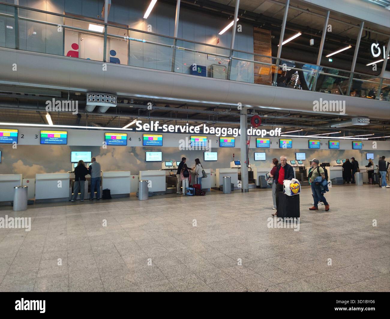 Gepäckabgabebereich am Flughafen Eindhoven, an dem Reisende ihr Gepäck aufgeben Stockfoto