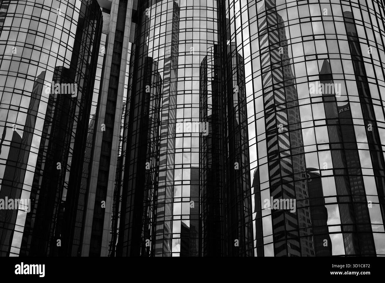 Glasfassaden-Reflektionen in Schwarz und weiß – abstrakte Architektur mit Symmetrie, Tiefe und moderner urbaner Geometrie Stockfoto