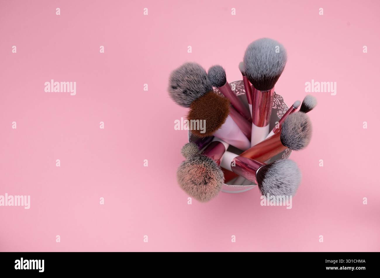 Make-up-Pinsel stehen in Einem Halter vor rosa Hintergrund. Stockfoto