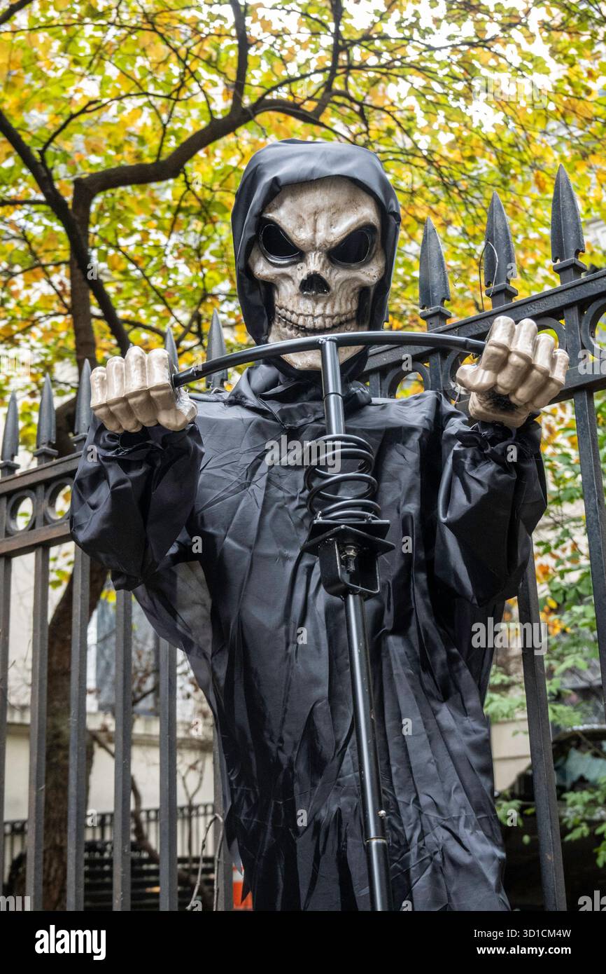 Nahaufnahme eines Halloween Grim Reaper, der ein Grab auf einem Friedhof gräbt, 2025, New York City, USA Stockfoto