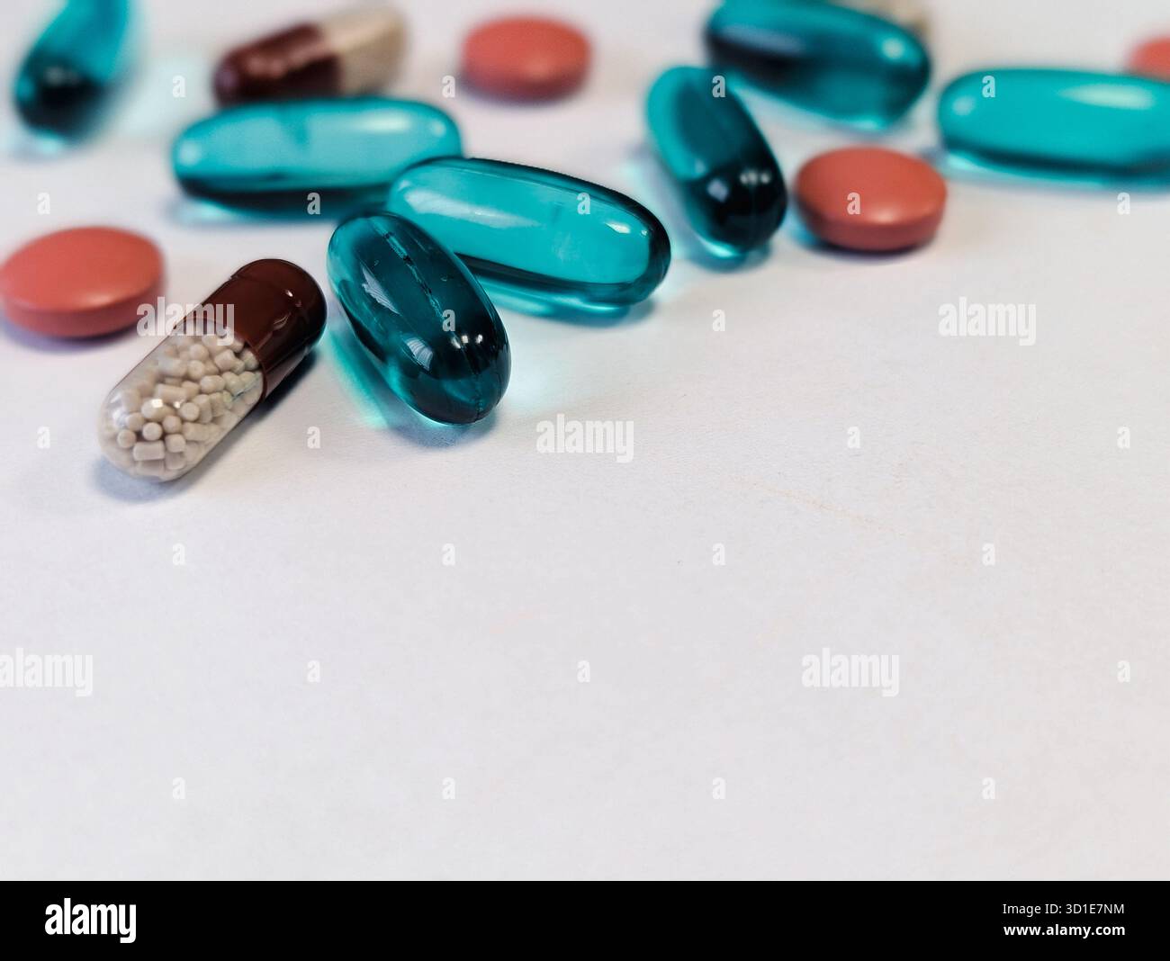 Nahaufnahme verschiedener pharmazeutischer Tabletten und Kapseln, verstreut auf weißem Hintergrund - Smartphone-aufgenommenes Stockfoto