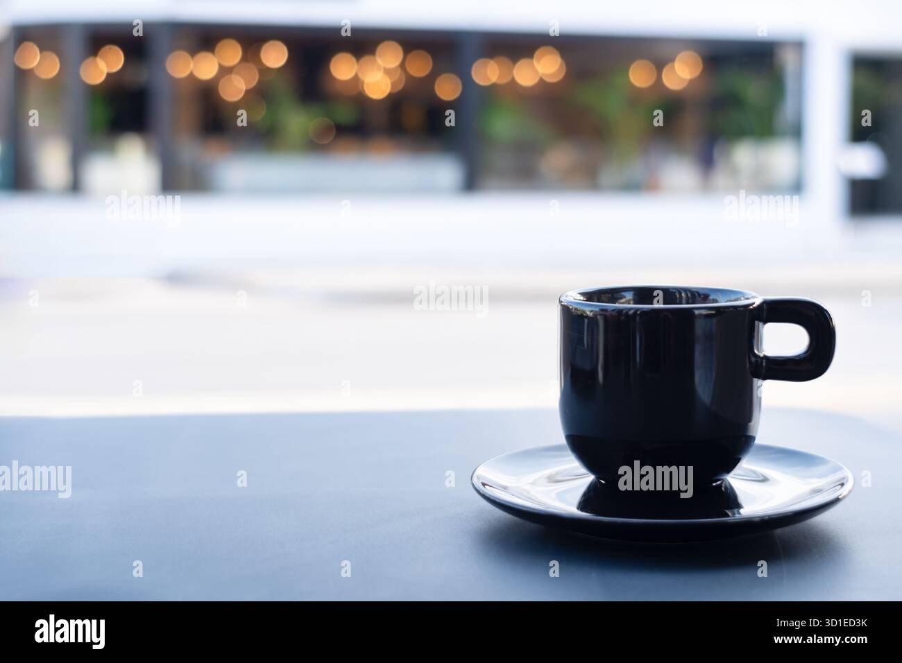 Rhodos, Griechenland. Ein einzelnes Heißgetränk oder Getränk, serviert in einer schwarzen porzellantasse mit Untertasse und auf einem Straßencafé-Tisch im Freien. Stockfoto