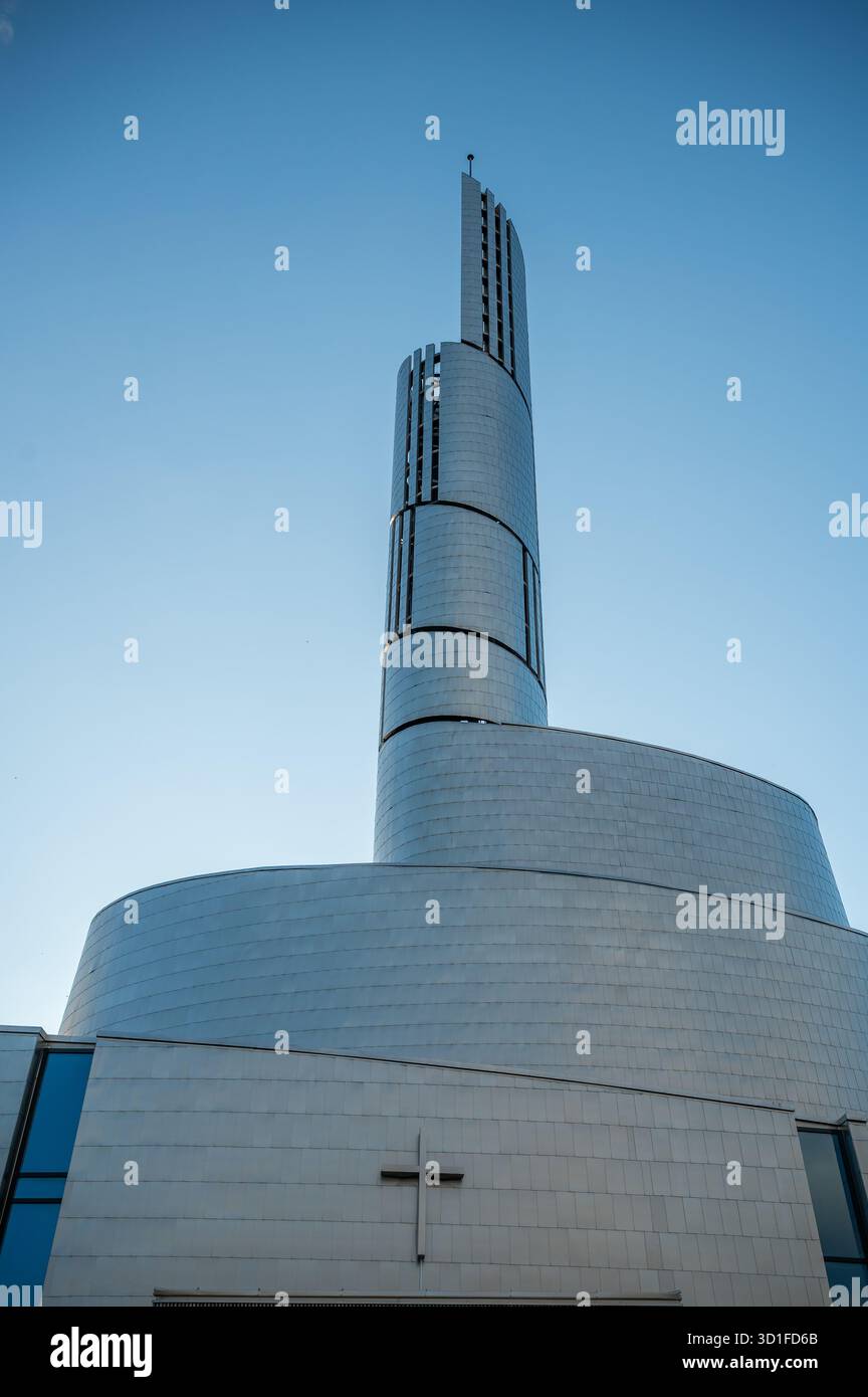 Northern Lights Cathedral, Alta, moderne Kirche mit einem markanten Spiralturm und einem Kreuz an der Fassade steht unter einem klaren blauen Himmel, vertikale Aufnahme, Stockfoto