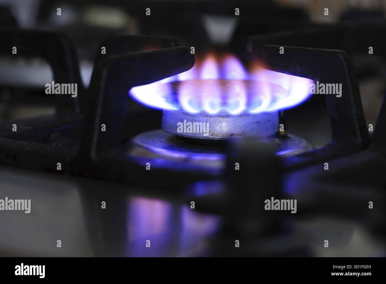Nahaufnahme des Gasherd-Brenners, Flamme zeigt schmutziges Erdgas an Stockfoto