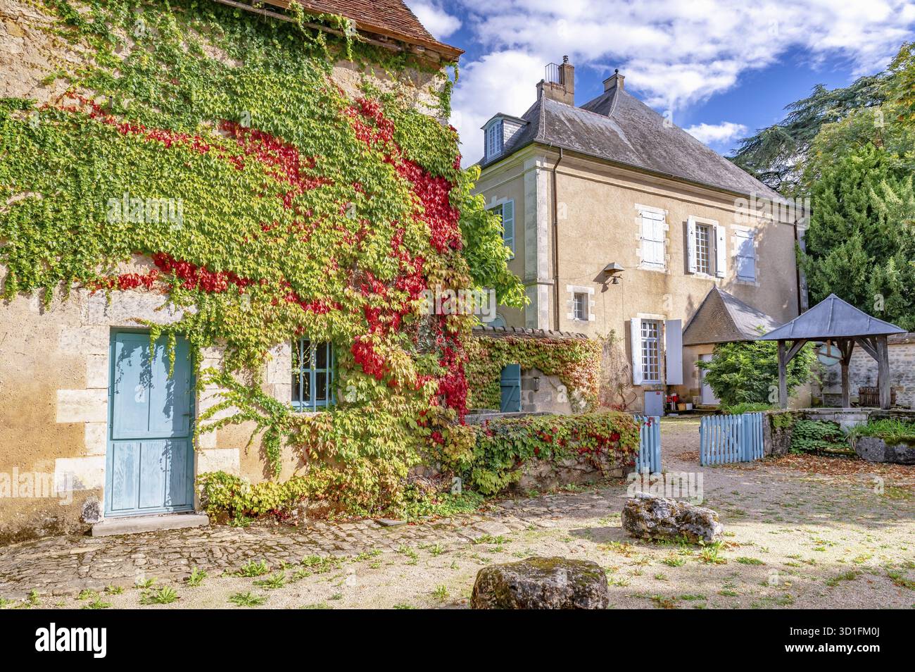 Blick auf das Maison George Sand vom Innenhof mit zwei historischen Gebäuden, von denen eines teilweise mit grünem und rotem Wildwein bedeckt ist, mit hellem blau Stockfoto