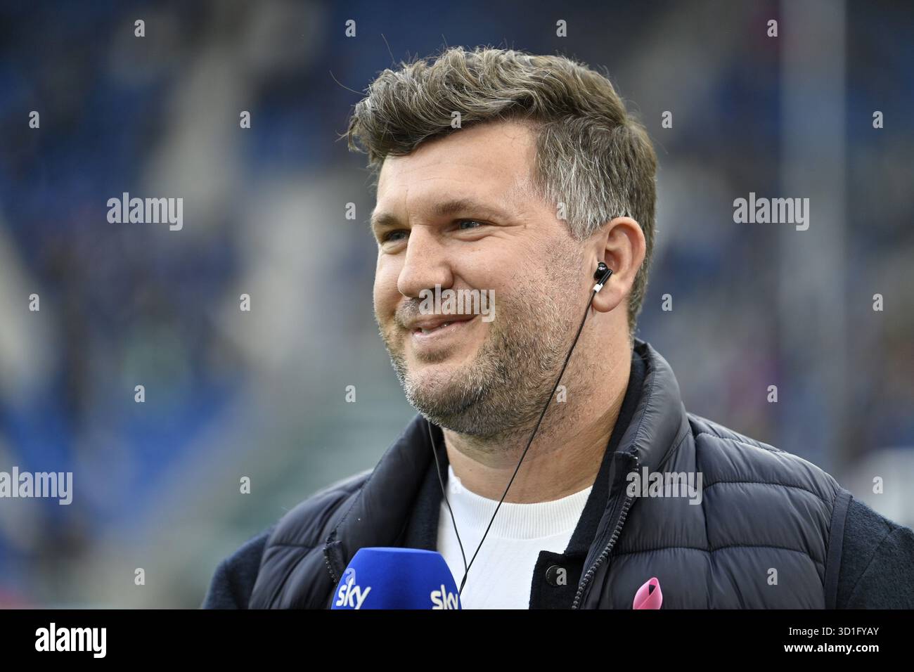 Sportdirektor Andreas Schicker TSG 1899 Hoffenheim Portrait Interview Mikrofon Mikro Logo SKY Smiling, PreZero Arena, Sinsheim, Baden-Württemberg Stockfoto