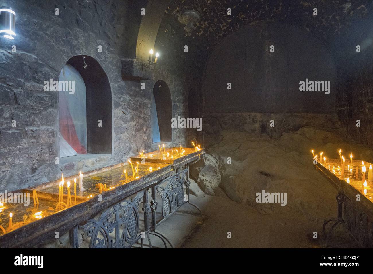 Der Raum mit Kerzenlicht schafft eine ruhige, gedämpfte Atmosphäre mit Steinmauern, Khor Virap Kloster, tiefem Kerker, Ararat Provinz, Armenien Stockfoto