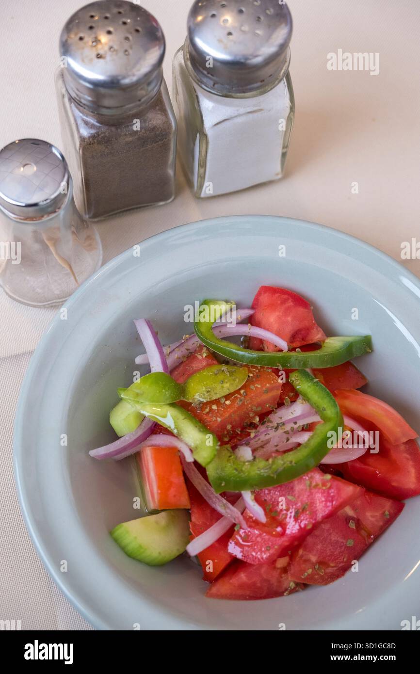 Vorspeiseteller mit Salat, Pfefferstreuer und Salzstreuer in einem Restaurant Stockfoto