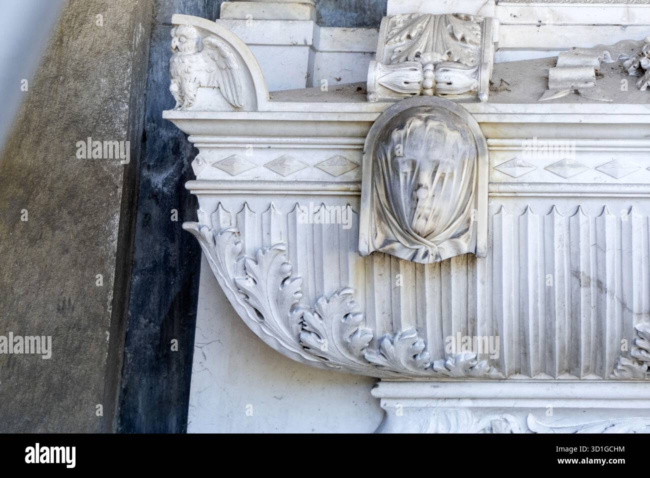 Detail des Grabdenkmals Martinengo Colleoni von Giovanni Spertini: Marmoreule, verschleiertes Gesicht und Akanthusblätter. Stockfoto