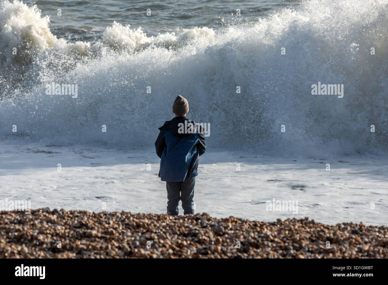 Brighton, 28. Oktober 2025: A Young Boy Watching Waves Crash on the Beach Credit: Andrew Hasson/Alamy Live News Stockfoto