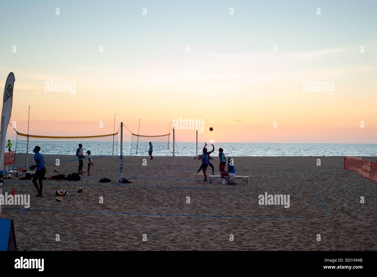 LUANDA, ANGOLA - 29. APRIL 2025: Menschen spielen Volleyball am Strand von Ilha de Luanda bei Sonnenuntergang Stockfoto