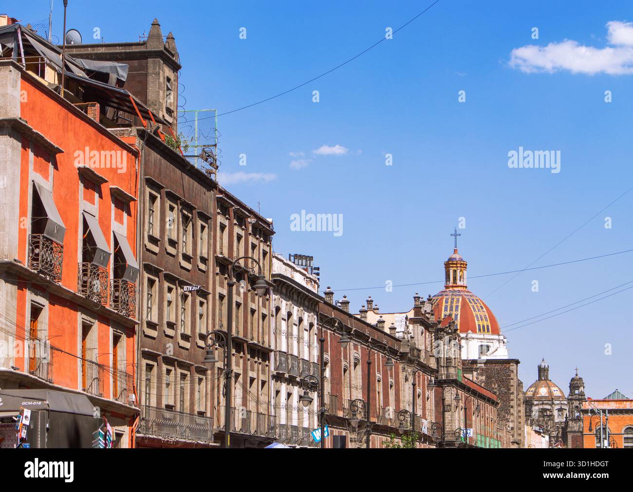Farbenfrohe Kolonialarchitektur in Mexiko-Stadt mit roten und gelben Fassaden unter klarem blauen Himmel, historischer Innenstadt und Kulturerbe-Szene Stockfoto