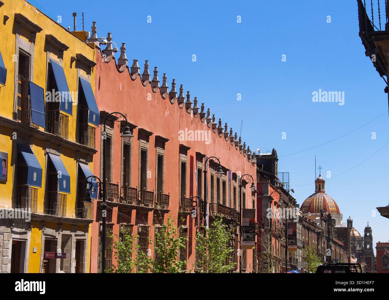 Farbenfrohe Kolonialarchitektur in Mexiko-Stadt mit roten und gelben Fassaden unter klarem blauen Himmel, historischer Innenstadt und Kulturerbe-Szene Stockfoto