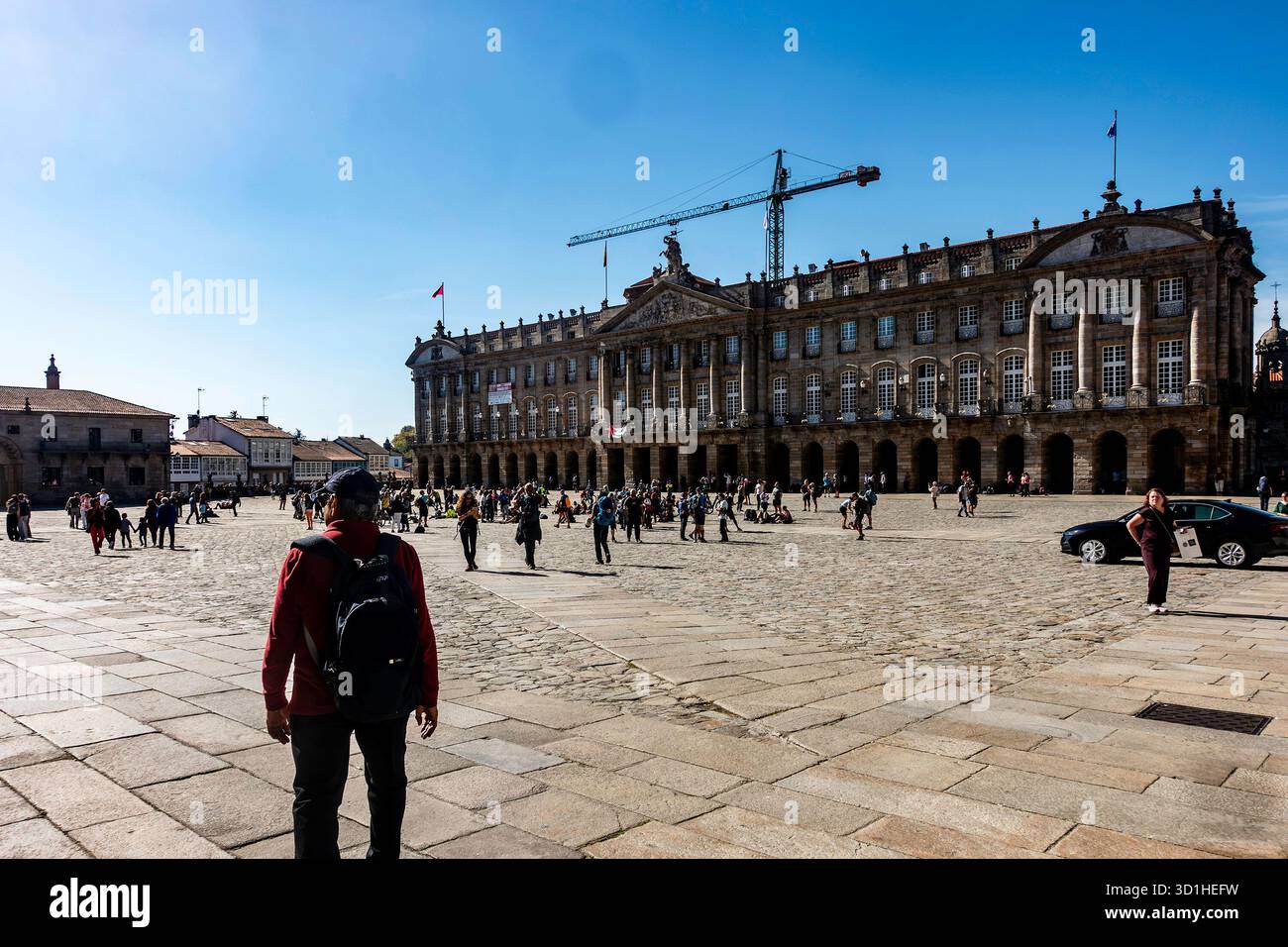 Touristen und Pilger treffen sich in Praza do Obradoiro, Santiago de Compostela, Galicien, Spanien, mit dem neoklassizistischen Regierungsgebäude Pazo de Raxoi. Stockfoto