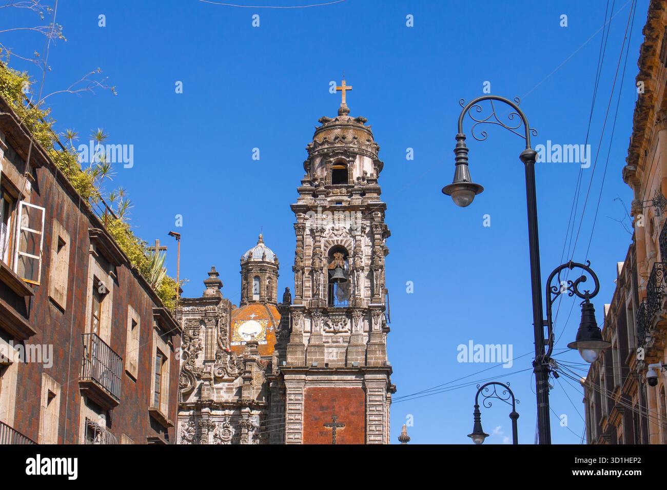 Historischer Kirchturm und Kolonialstraße unter tiefblauem Himmel in Mexiko-Stadt – Vintage-Architektur und urbane Kulturerbe-Szene Stockfoto