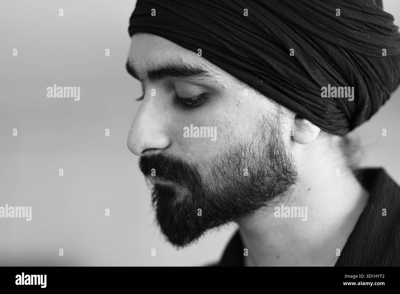Cremona, Italien - 21. Juli 2025 Nahaufnahme eines bärtigen Mannes, der einen Turban mit geschlossenen Augen trägt, in Nachsicht und Reflexion mit einem Gedanken provoki Stockfoto
