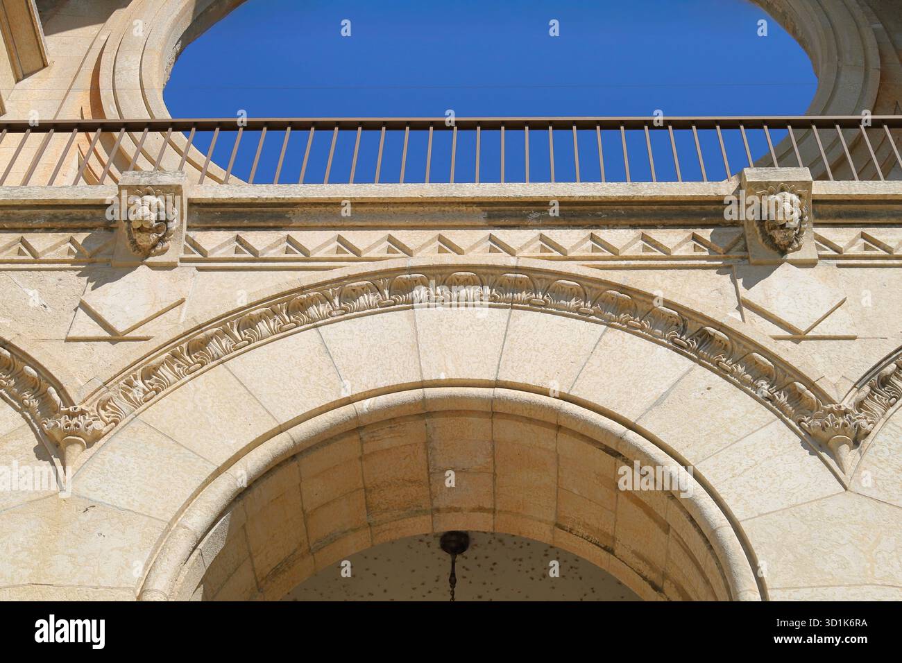 Historische Steinbögen mit verzierten Details. Elegante historische Gebäudefassade mit Steinbögen, dekorativen Schnitzereien und klassischen architektonischen Elementen Stockfoto