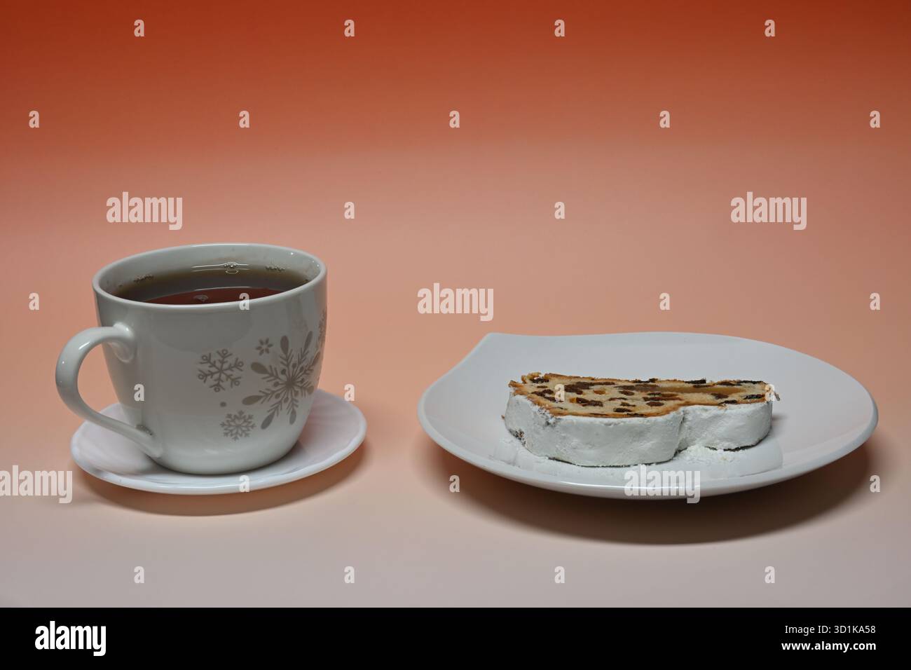 Stollen und weiße Tasse schwarzen Tee mit Schneeflocken Stockfoto