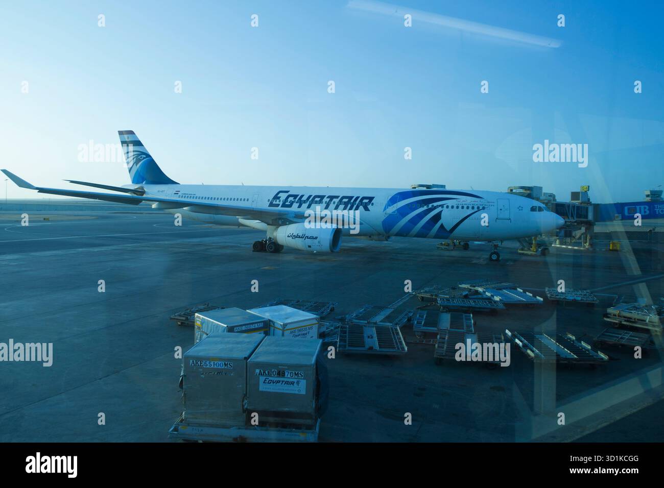 Die ÄgyptAir-Flugzeuge parkten am frühen Morgen am Flughafentor mit Bodendienstausrüstung und Frachtcontainern in der Nähe Stockfoto