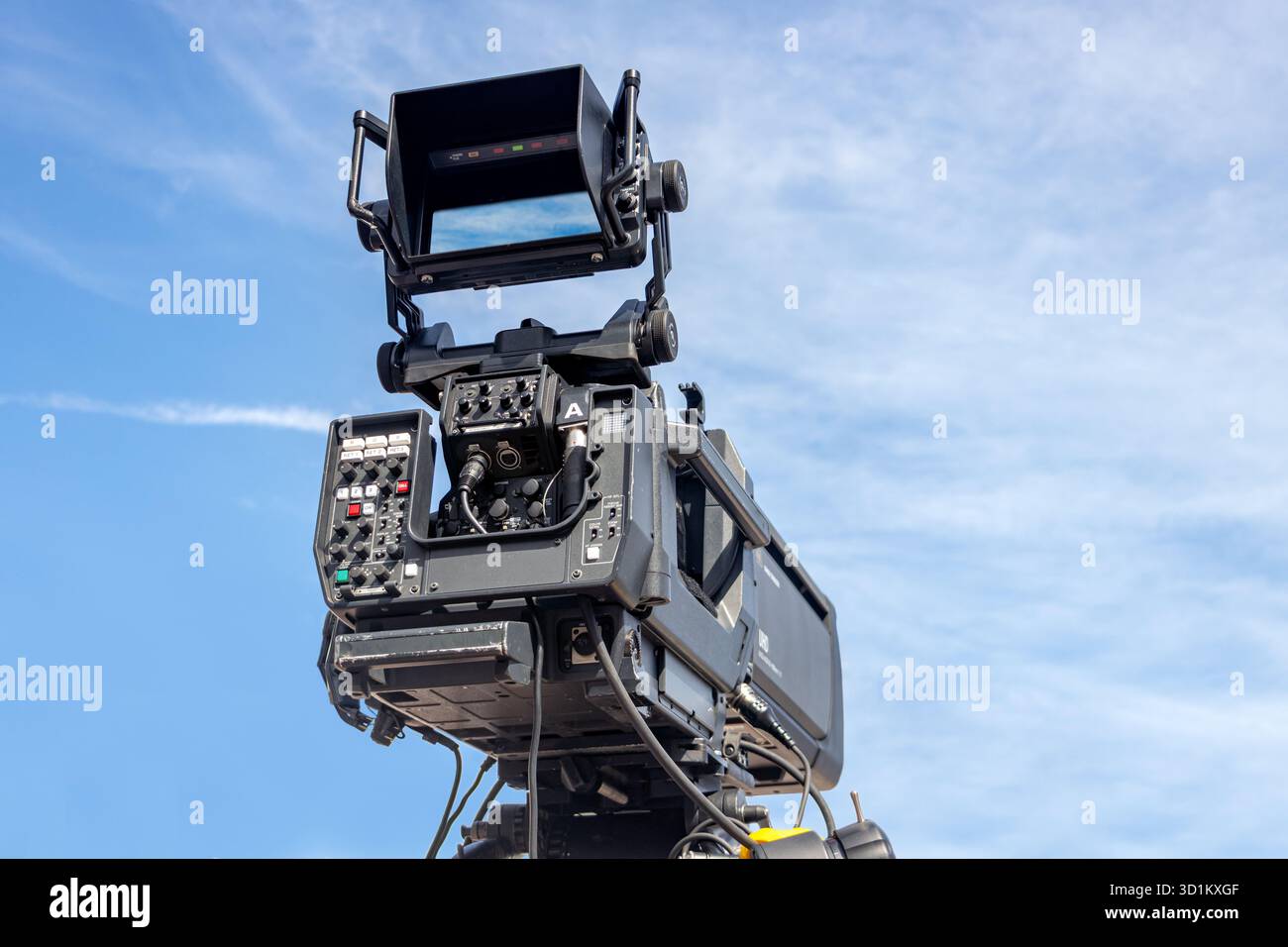Professionelle Kamera auf einem massiven Stativarm vor klarem blauem Himmel, bereit für Film- und fernsehproduktionen Stockfoto