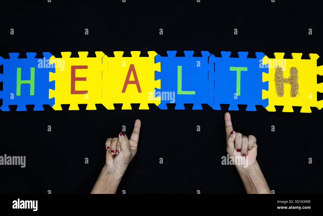Zwei Hände zeigen auf das Wort Gesundheit für körperliches und geistiges Wohlbefinden Konzept Stockfoto