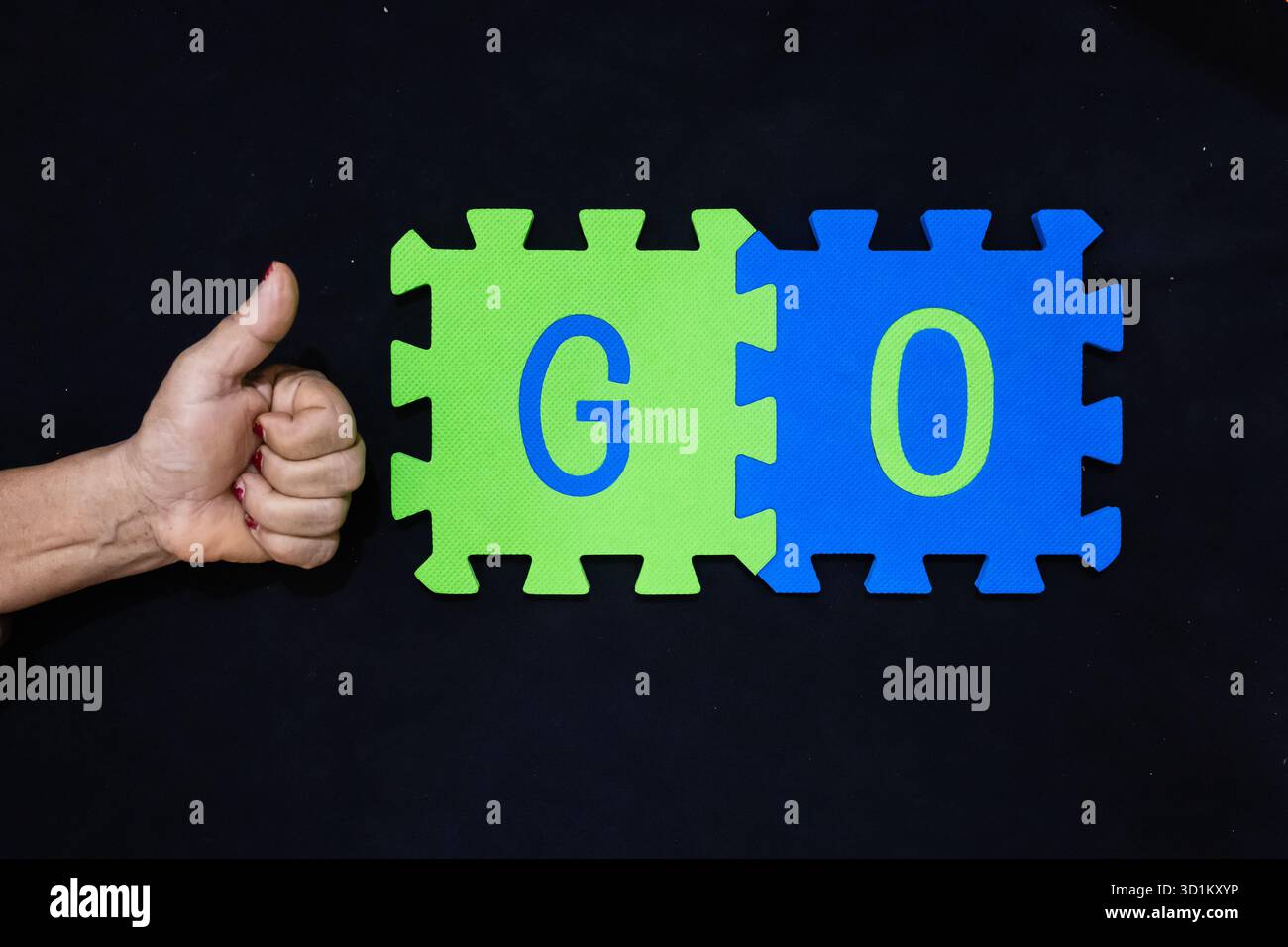 Action und Anfangswort gehen auf grüne und blaue Puzzleteile Stockfoto