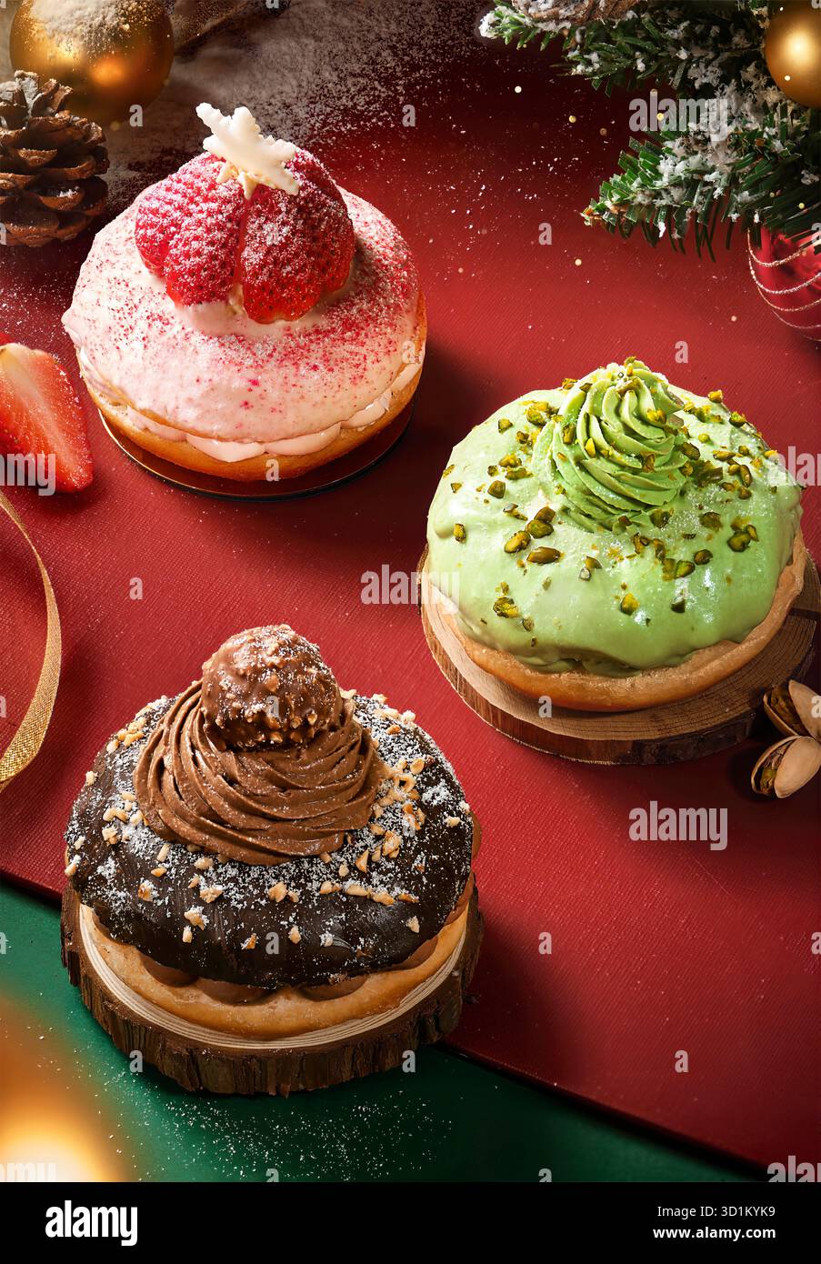 Festliche Weihnachts-Donuts mit Erdbeere Pistazie und Schokolade Toppings auf rotem Feiertagshintergrund Stockbild Stockfoto