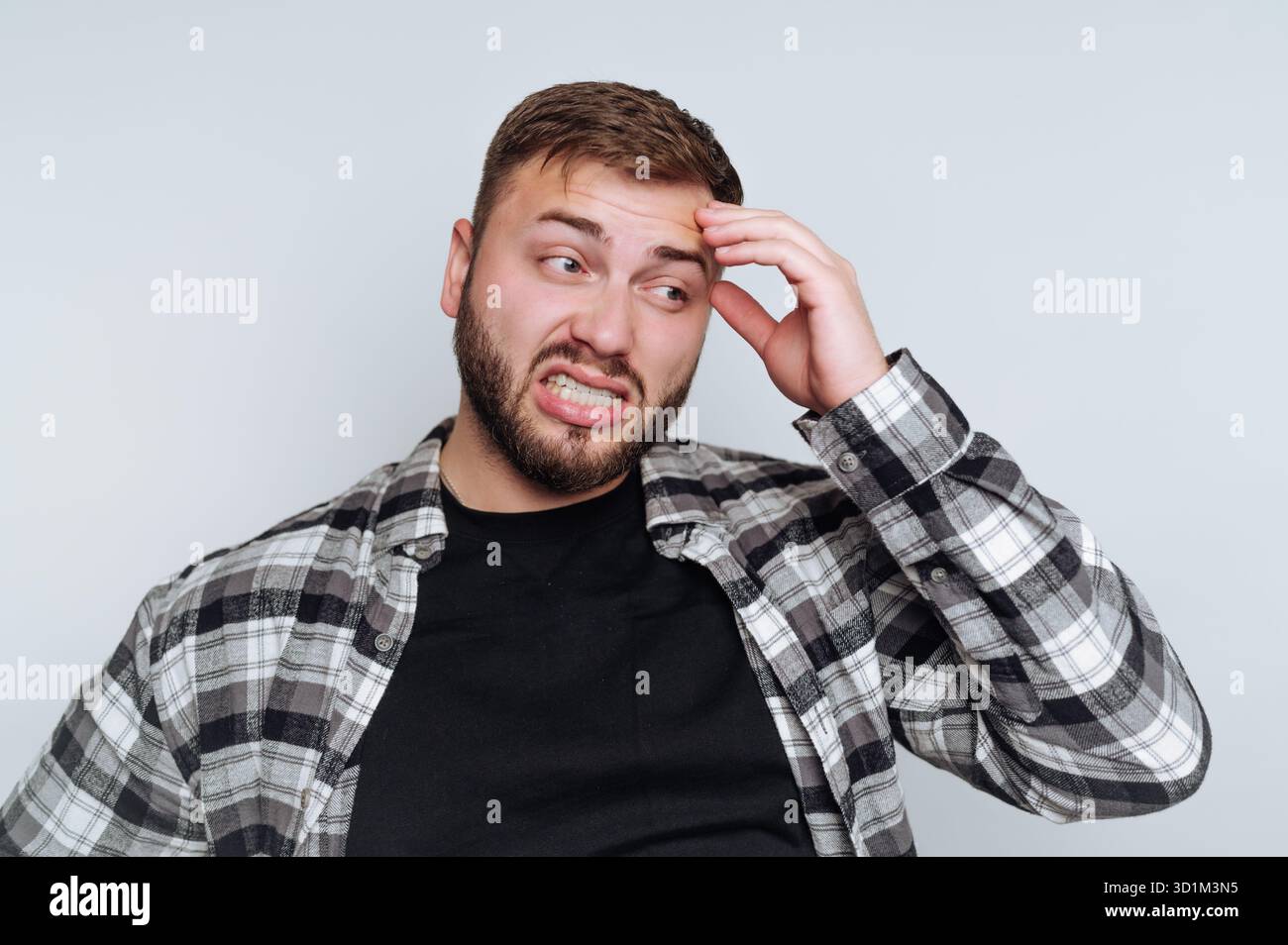 Mann in kariertem Hemd, der verwirrt und frustriert aussieht Stockfoto