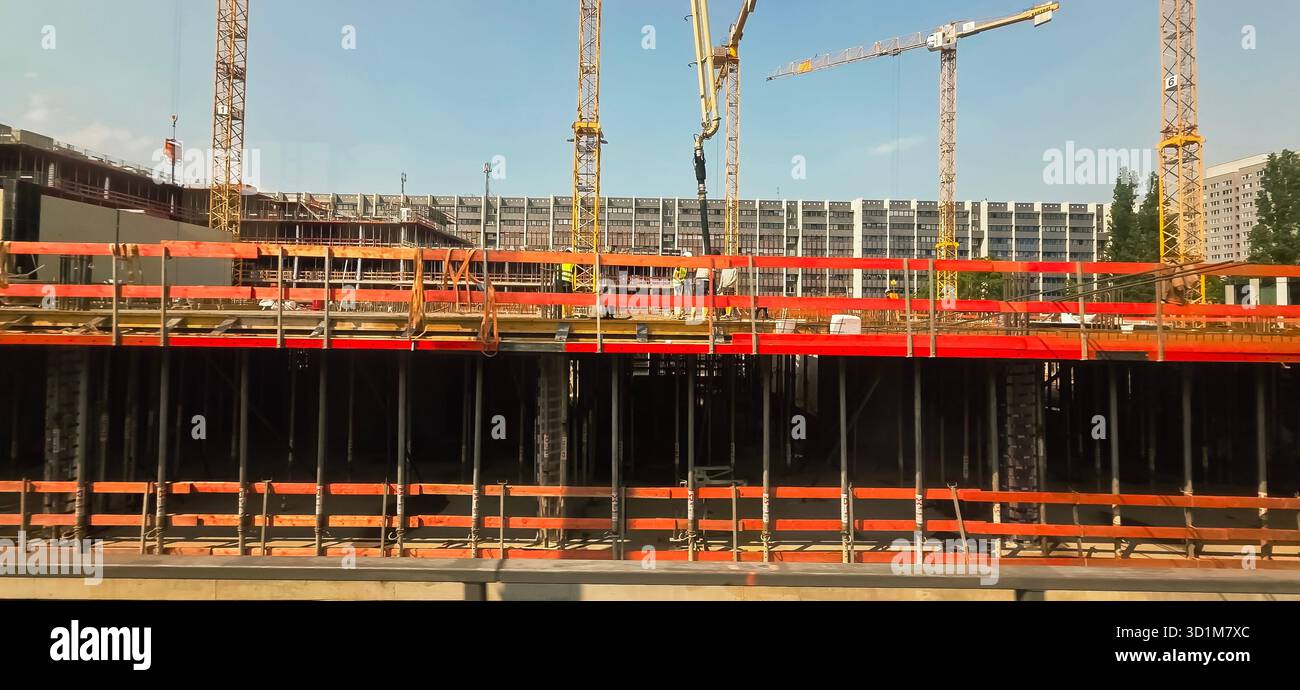 Berlin - 02. Juni 2025: Baustelle mit Kranen und Gerüsten vor klarem blauem Himmel. - Smartphone-aufgenommenes Stockfoto