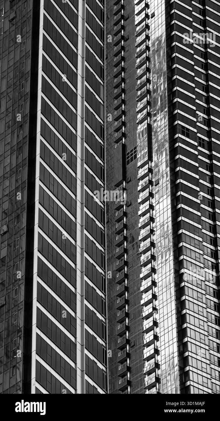 BUSAN, SÜDKOREA - 9. OKTOBER 2025 - Wolkenkratzer-Fassade mit abstrakten geometrischen Mustern und reflektierendem Licht in Schwarz-weiß Stockfoto