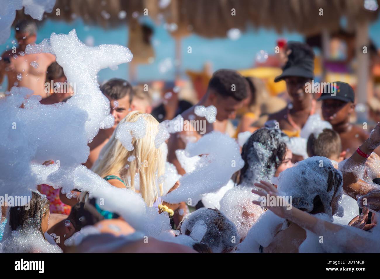 Eine lebhafte Schaumparty in Hurghada, Ägypten, zeigt eine Menge von Menschen, die in dicke Bläschen getaucht sind, lachen und die verspielte Sommeratmosphäre unter der Th genießen Stockfoto