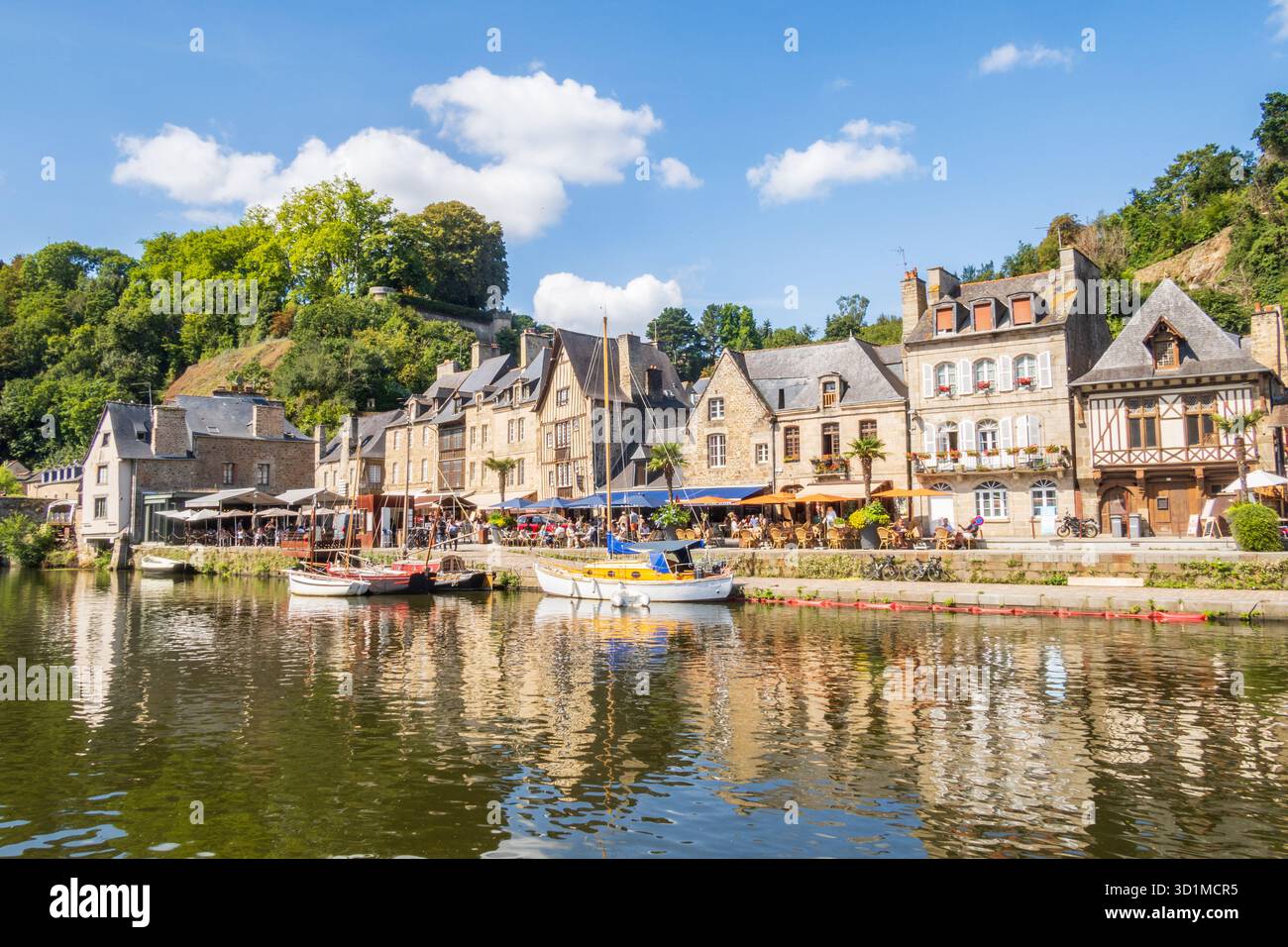 Dinan, Frankreich 22. August 2025: Der Hafen von Dinan an der Rance mit Touristen auf Restauranterrassen in der Bretagne, Frankreich Stockfoto