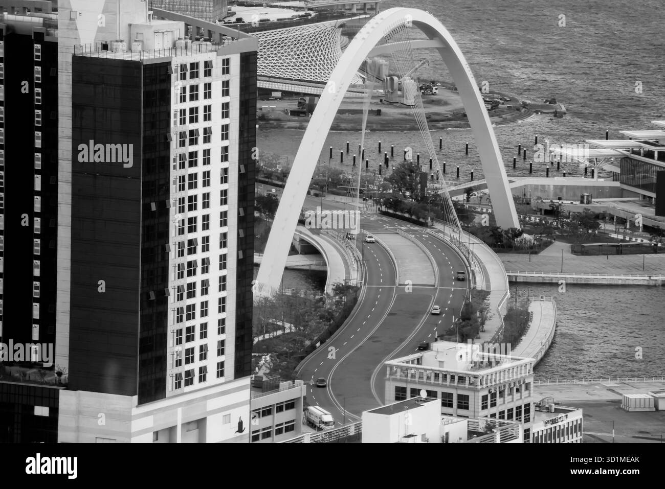 BUSAN, SÜDKOREA - 9. OKTOBER 2025 - die Skyline von Busan bietet moderne Architektur, Bogenbrücke und geschäftigen Straßenverkehr in Schwarz-weiß Stockfoto