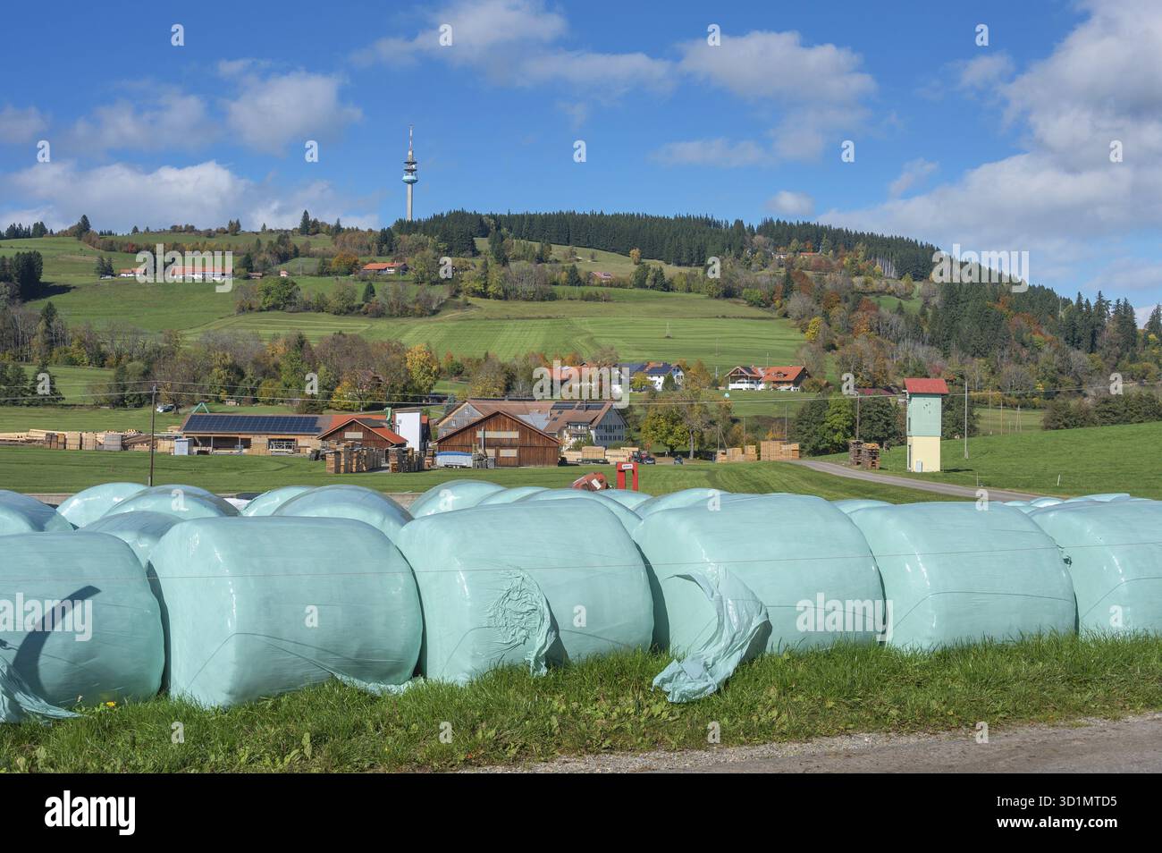 Blauer Himmel mit Wolken, Silageballen vor dem Dorf Masers unter dem Berg Blender mit Telekommunikationsturm bei Kempten, Schwaben, Ba Stockfoto