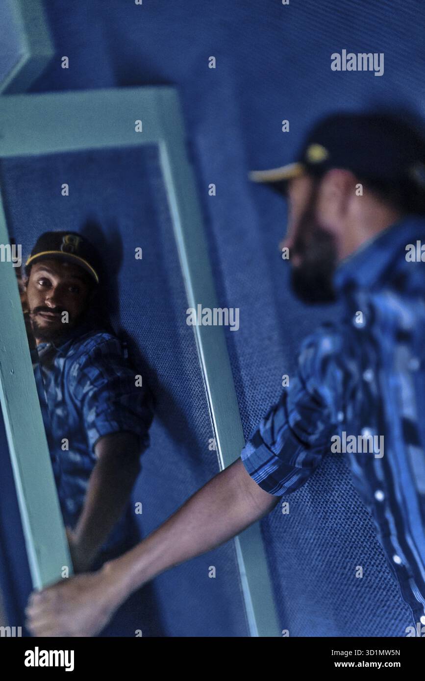 NUR REDAKTION und NACHRICHTEN, Promi und Stand-up-Comedian Matt Okine, der sich im Spiegel hinter der Bühne mit introspektiver Selbstwahrnehmung ein paar Meilen ansieht Stockfoto