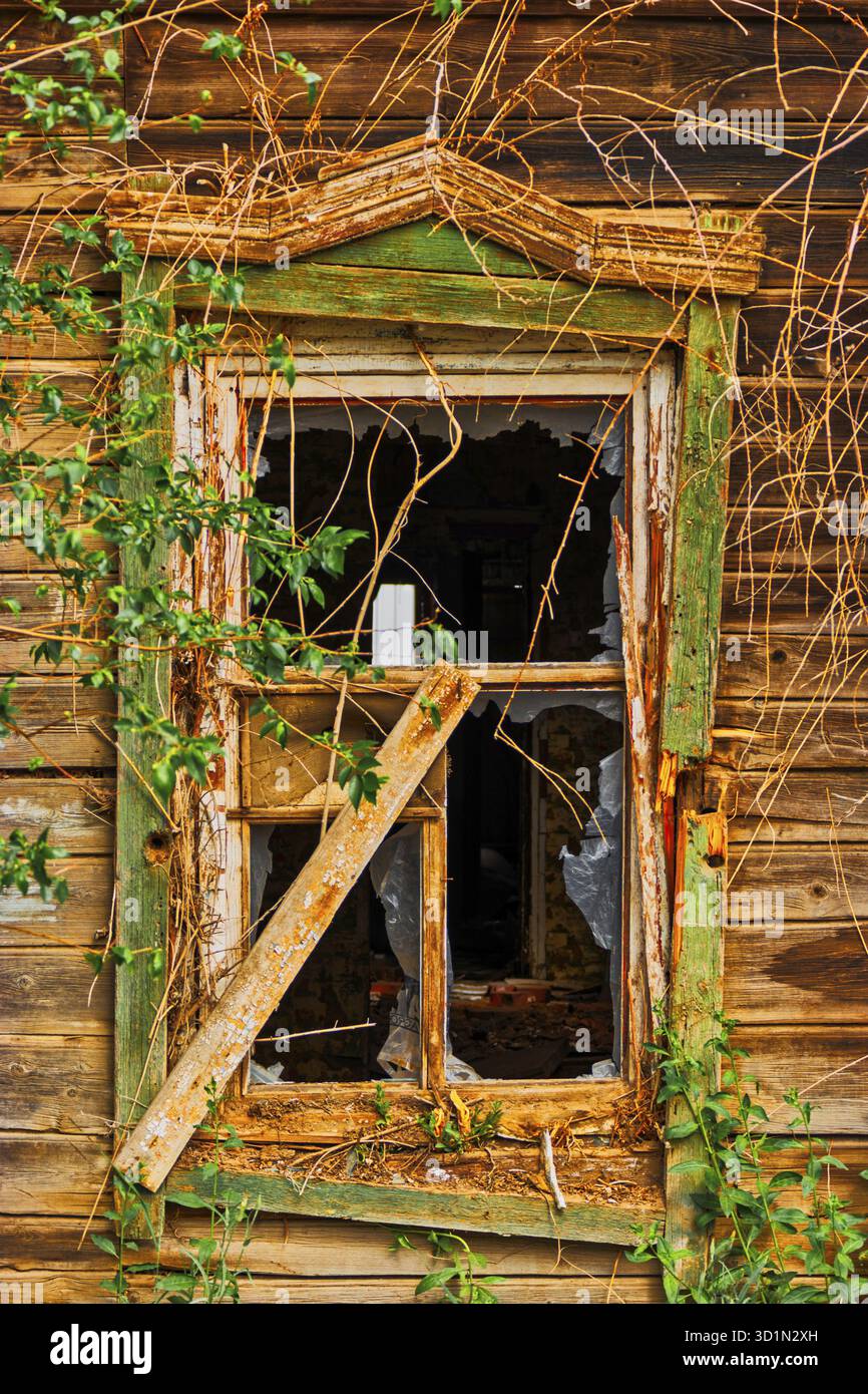 Kaputtes Fenster eines alten Holzhauses im volksrussischen Stil ohne Brille Stockfoto