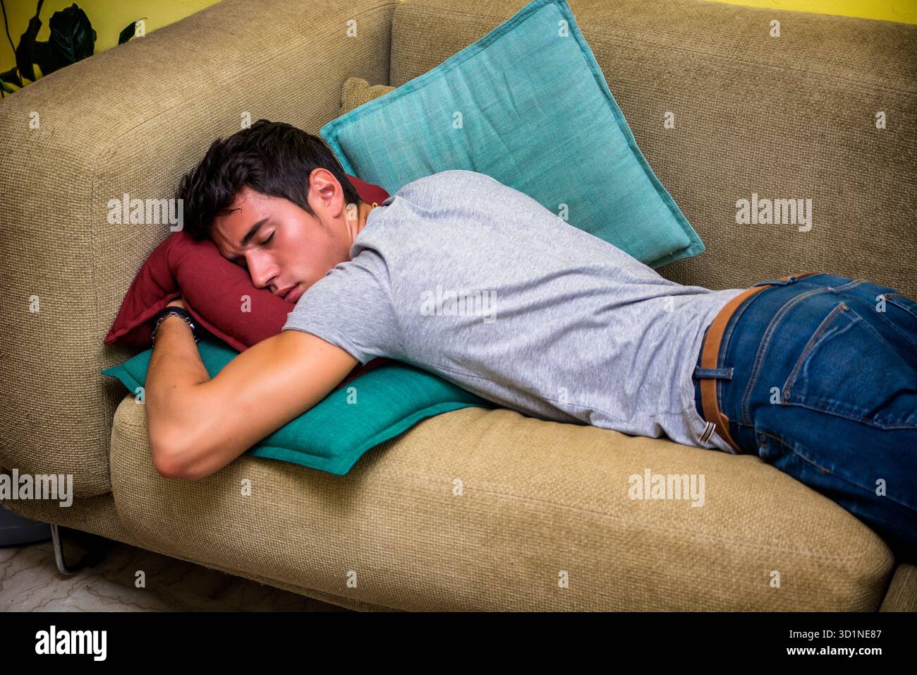 Betrunkener junger Mann, der auf der Wohnzimmercouch schläft Stockfoto