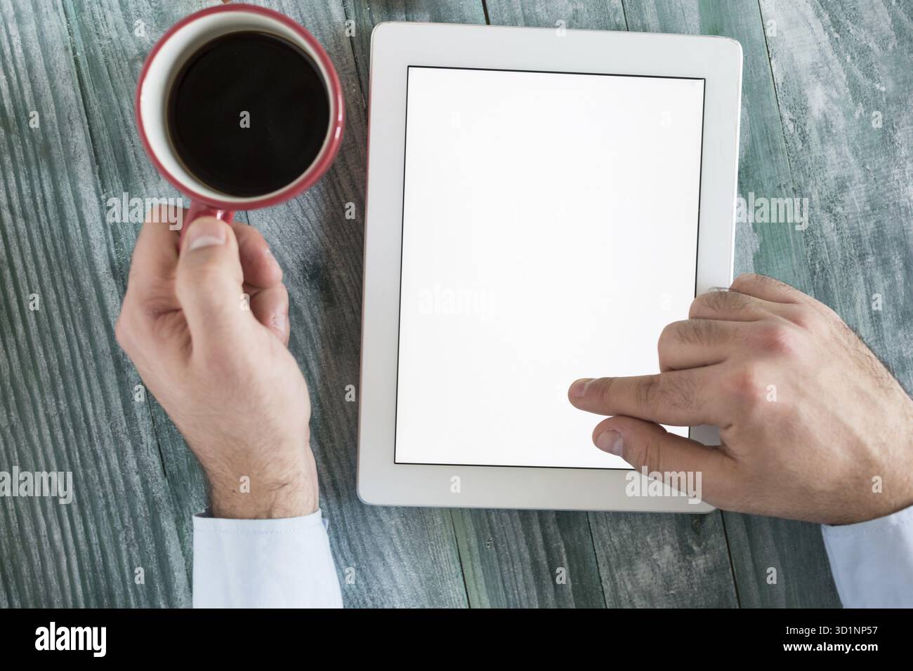 Hand mit Mockup Tablet ähnlich dem ipad-Stil auf Holzschreibtisch weißes Display mit Beschneidungspfad Bildschirm einfaches Hinzufügen von Bild Stockfoto
