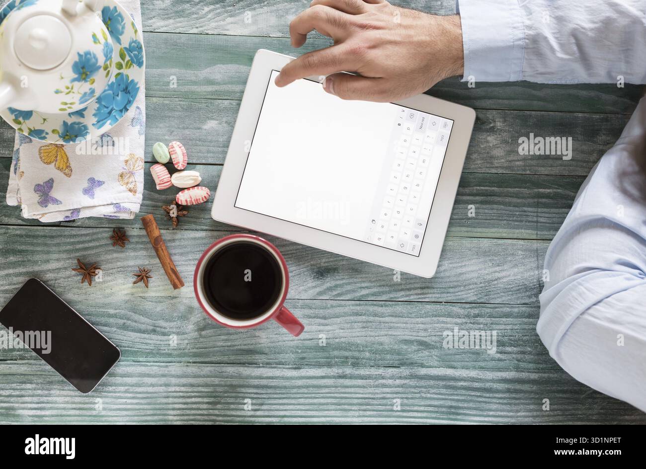 Hand mit Mockup Tablet ähnlich dem ipad-Stil auf Holzschreibtisch weißes Display mit Beschneidungspfad Bildschirm einfaches Hinzufügen von Bild Stockfoto
