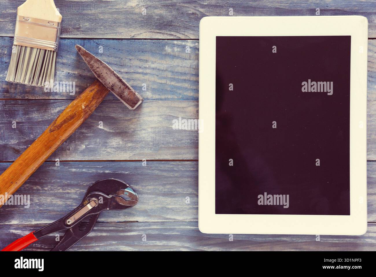 Top View Digital-Tablette und verschiedene Holzarbeiten und Zimmerhandwerk-Werkzeuge auf rustikalen Workshoptisch Stockfoto