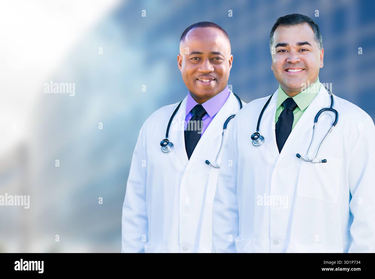 Afroamerikanische und hispanische männliche Ärzte vor dem Krankenhausgebäude Stockfoto