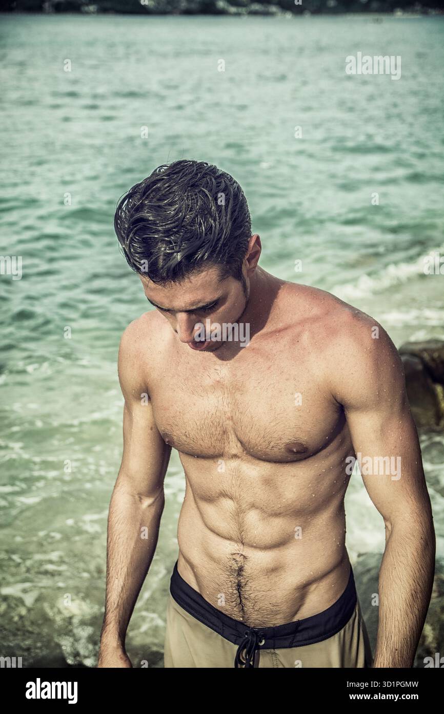 Hübscher junger Mann immer aus Wasser mit nassen Haaren Stockfoto