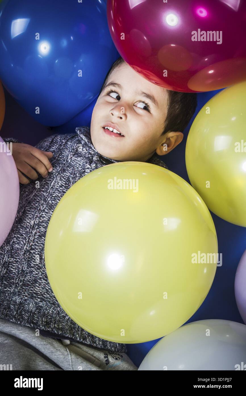 Spiel-junge Spiel mit Luftballons in vielen Farben Stockfoto