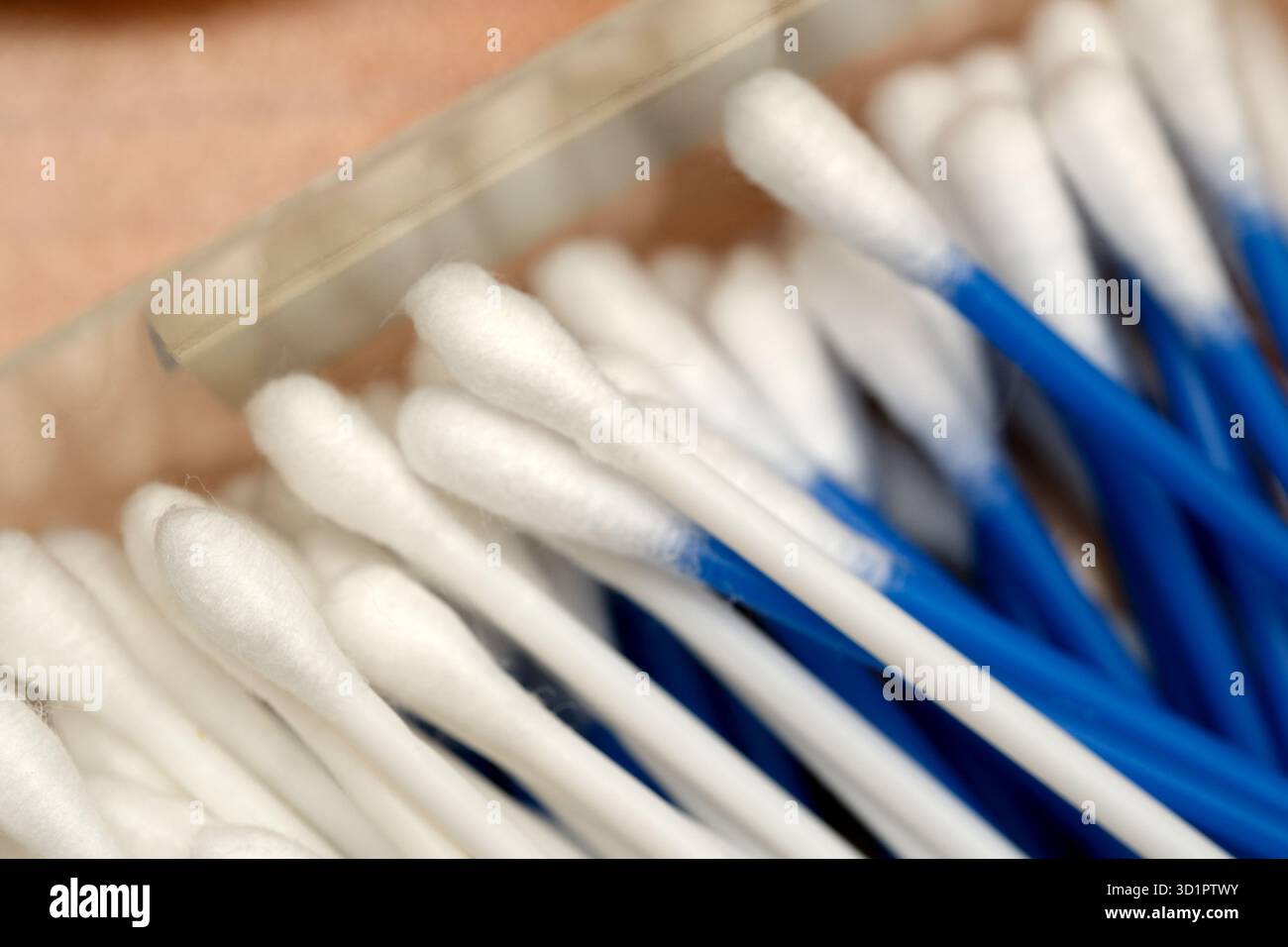 Wattestäbchen in verschiedenen Farben sind in einer transparenten Box für den täglichen Gebrauch angeordnet. Stockfoto